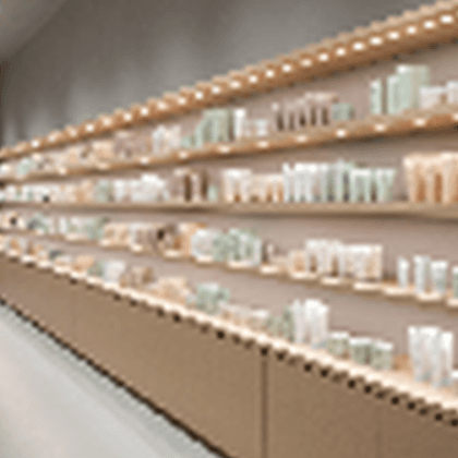 A cropped Korean beauty retail window scene with calm shelf zoning and warm editorial storefront light.